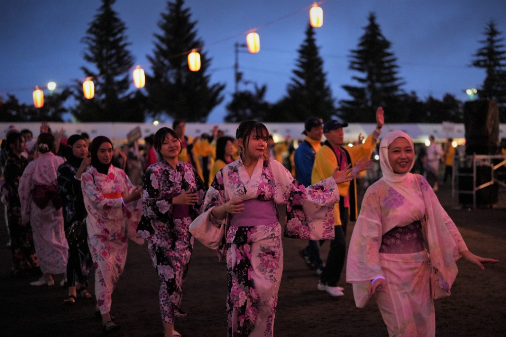 浴衣姿で盆踊りに参加する様子